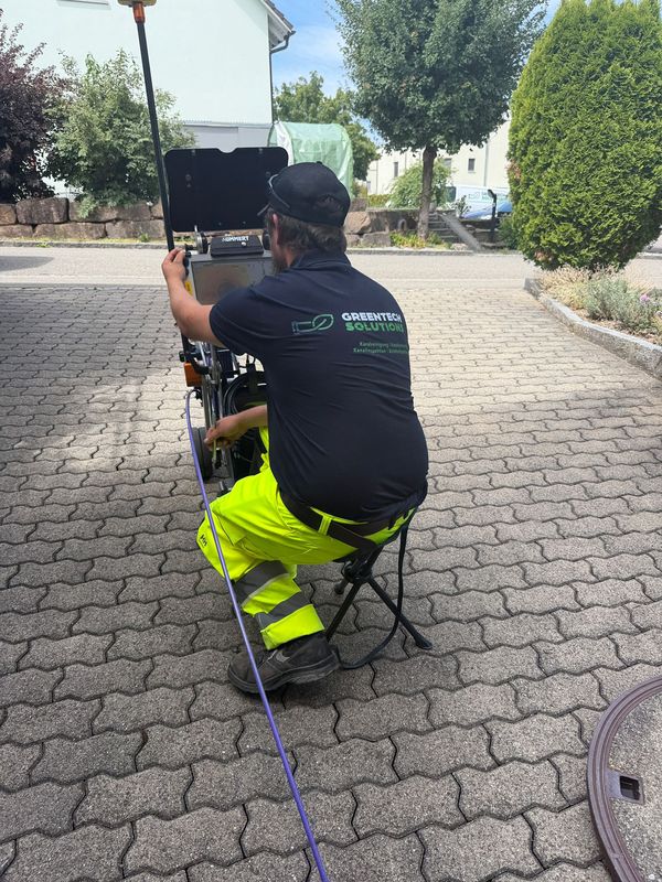 Greentech-Techniker sitzt am Monitor des Inspektionssystems und steuert die Kamerafahrt